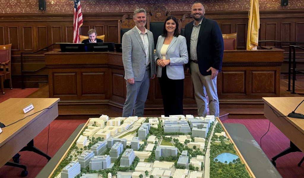 A 3D model of the Alewife campus, along with three professionals.