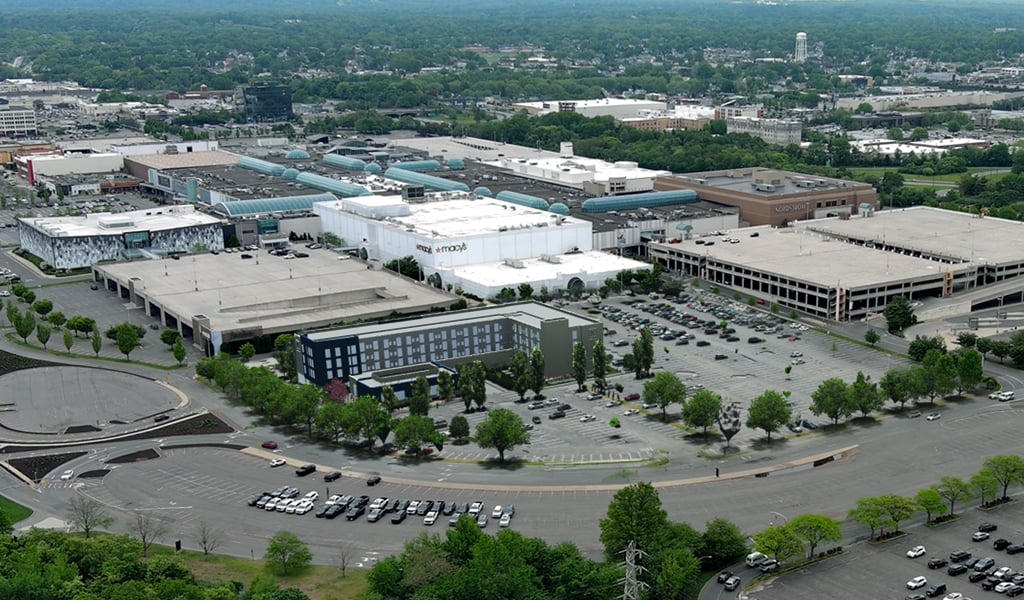 An oblique aerial of the Roosevelt Field Mall in New York depicting the new hotel in the foreground of the mall. 