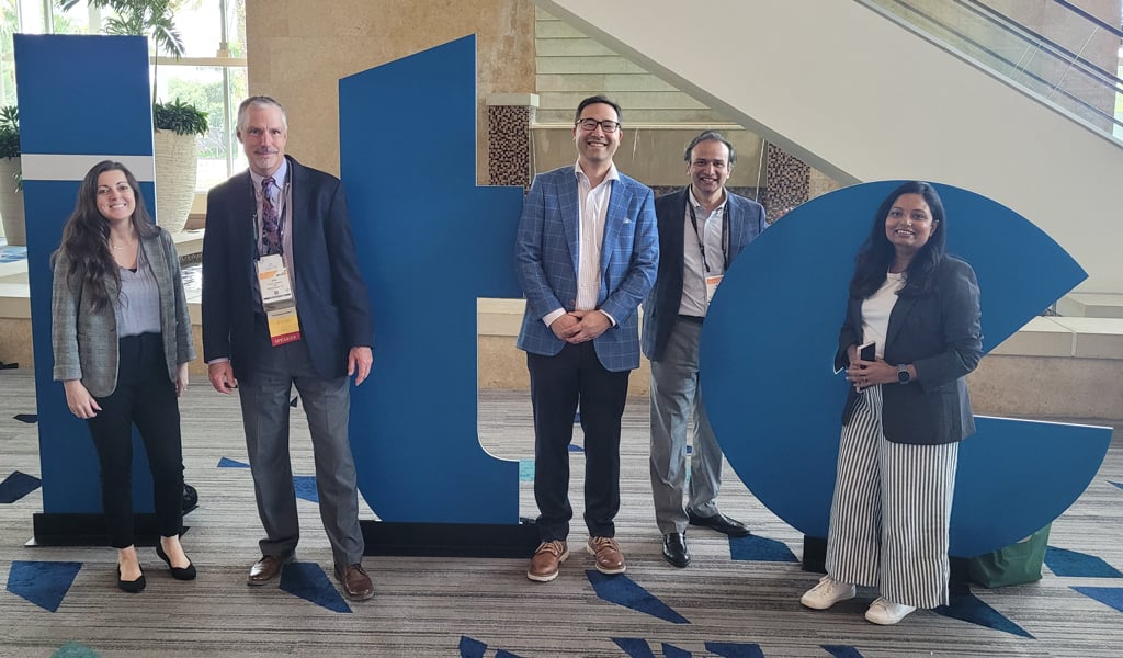 Five people standing in front of large blue letters "ITE" at a conference center.