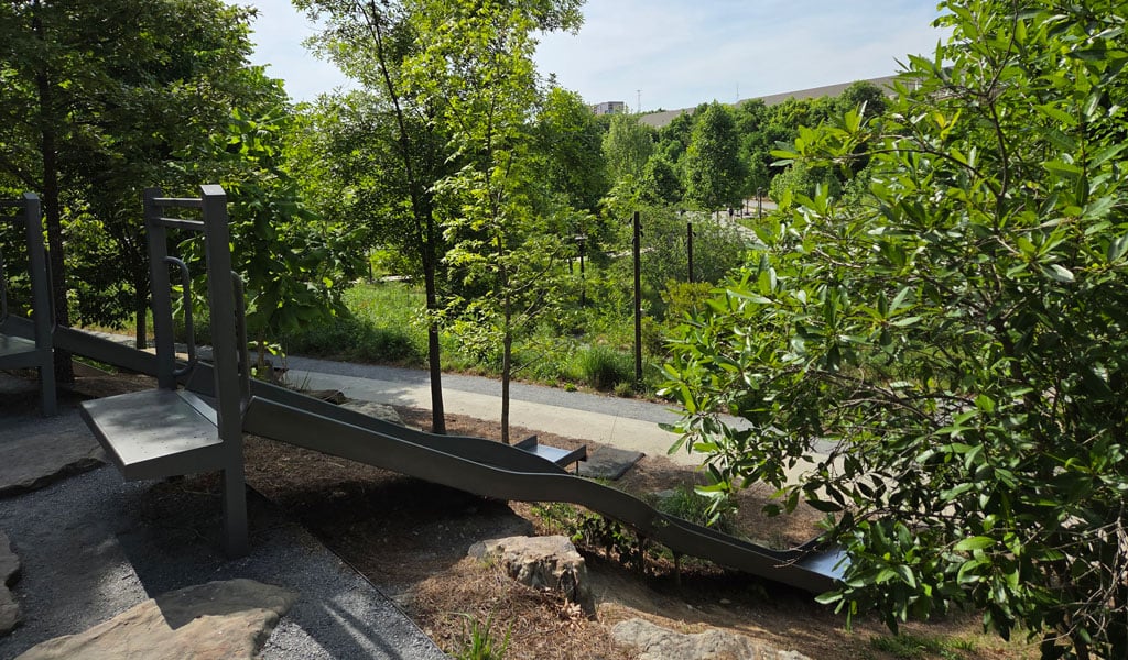 Playground tucked into a green, lush park.