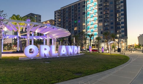 A sculpture of the word Orlando is lit up at night in Luminary Green Park