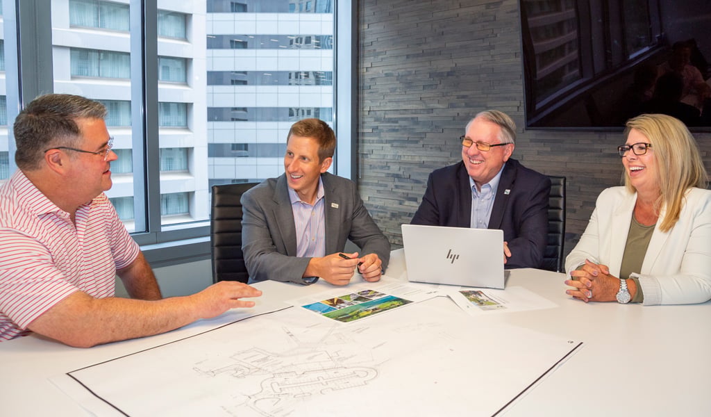 A group of four VHBers discussing Retail Program expansion plans. 