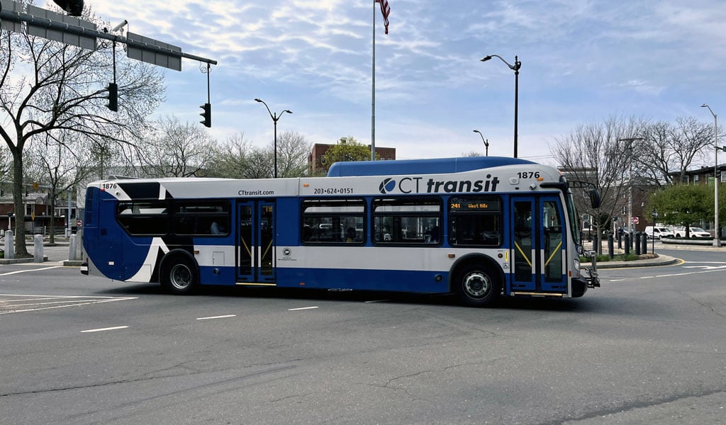 A blue-and-white CTtransit bus going through an intersection.