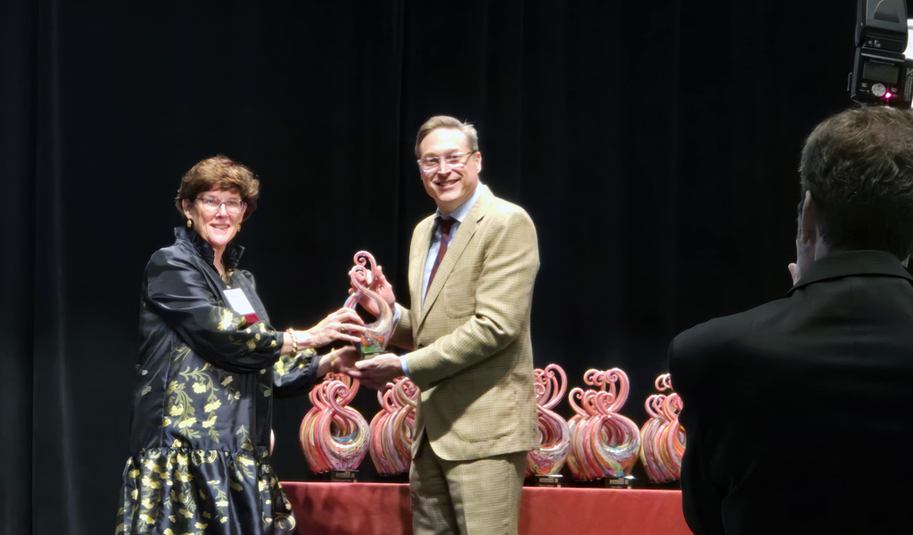 Nancy Barker accepts her Women in Leadership award on stage.