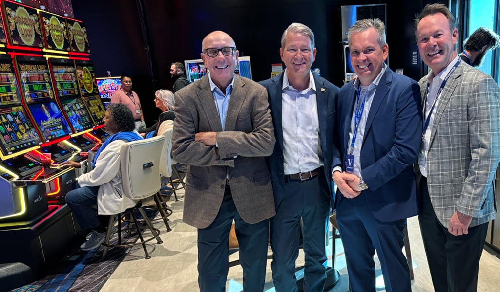 Four men in suits inside a gaming hall celebrating the opening day of The Interim Gaming Hall in Norfolk.
