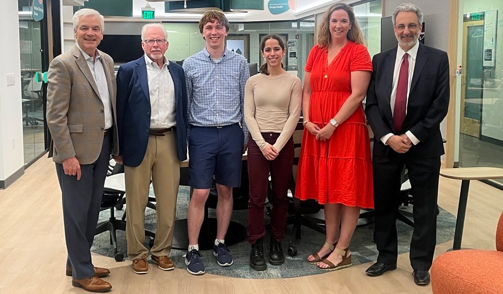 A group of leaders smiling with Northeastern scholarship recipients.
