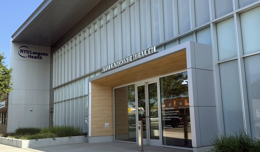 NYU Langone Health Ambulatory Care Center entrance, with glass façade, signage, sidewalk, and landscaped planters.