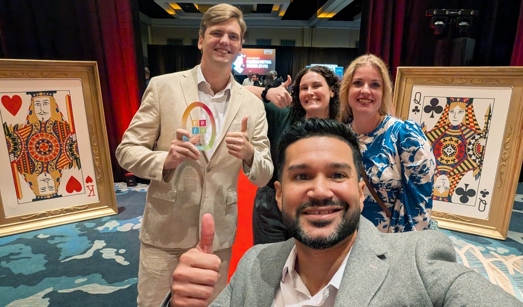 Danny, Stephen, Juliana and Signe stand in front of two giant playing card decorations.