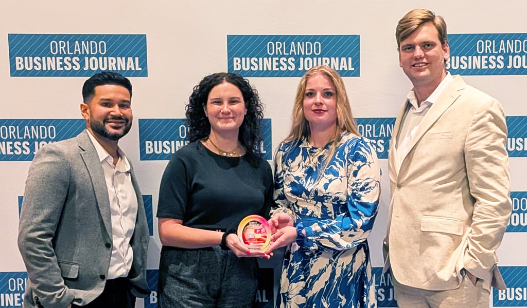 Danny, Julianna, Signe and Stephen standing together by the Orlando Business Journal sign.