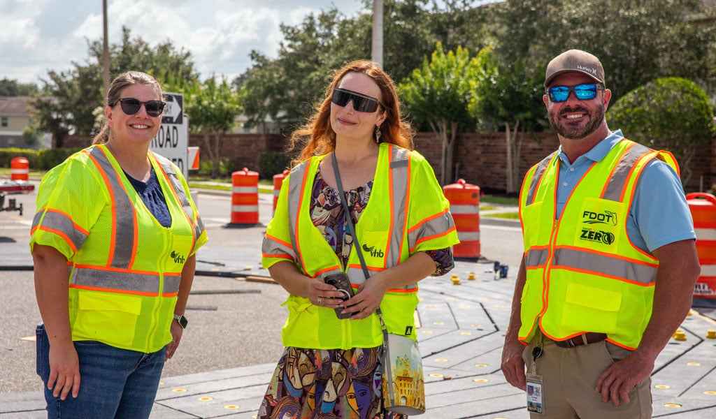 Jennifer DiStefana, Alla Kashirskaia and Eddie Quinn wearing construction vests.