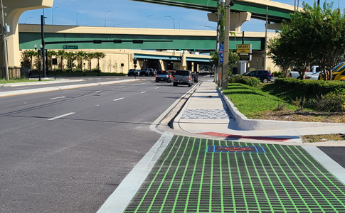 A bright green bicycle crosswalk with a logo for SODO across an intersection in downtown Orlando.