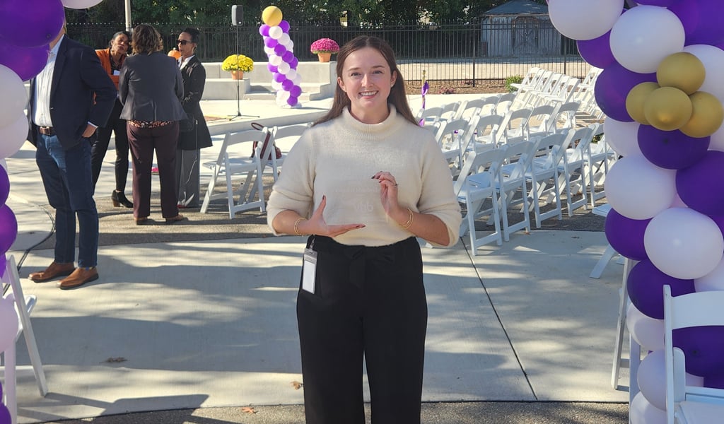 Peyton Ackerman smiling at the camera holding an award.