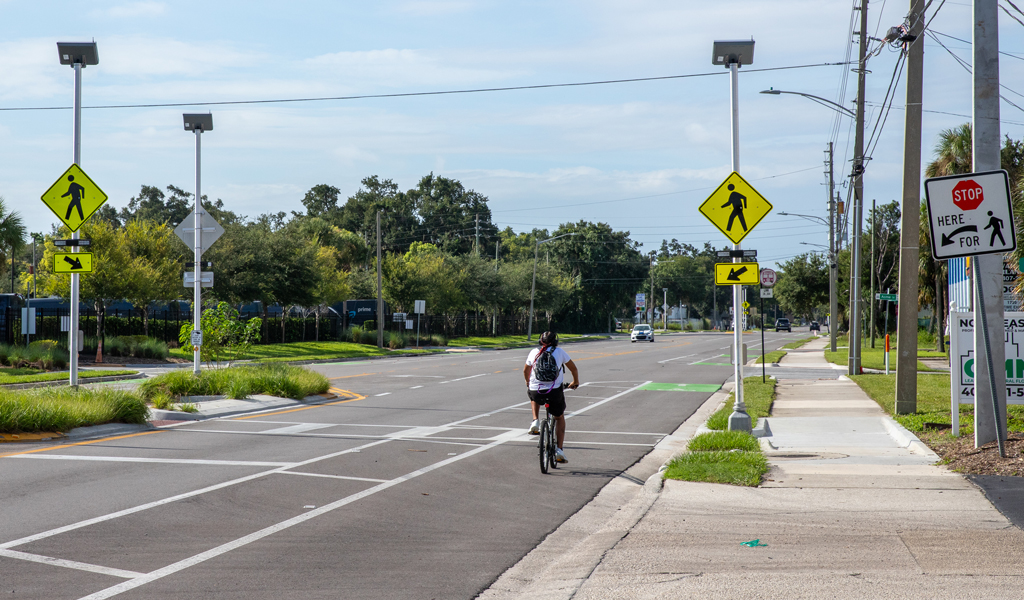 A man rides a bike in a safe bike lane.