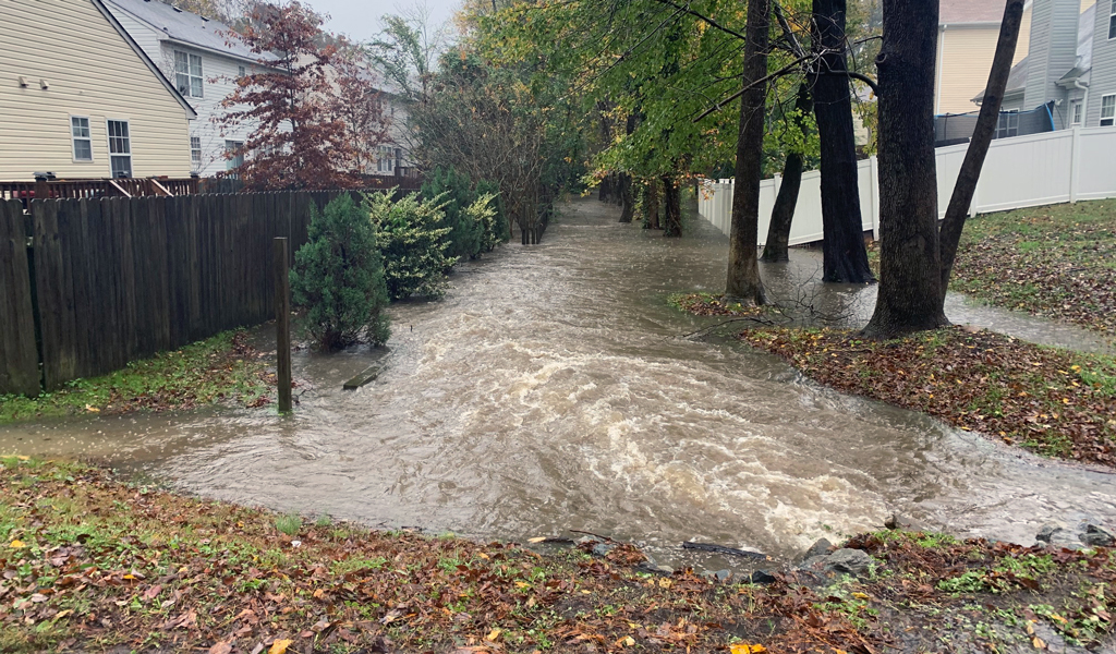 Flooding between fenced in backyards in residential neighborhood.