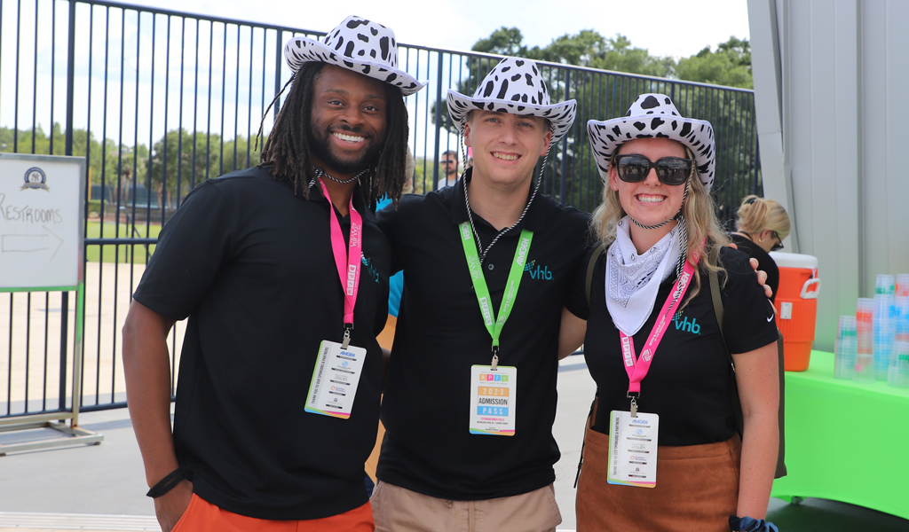Three VHB employees wearing funny hats and smiling