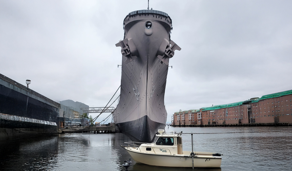 The VHB boat moves past the front of the USS Wisconsin. 