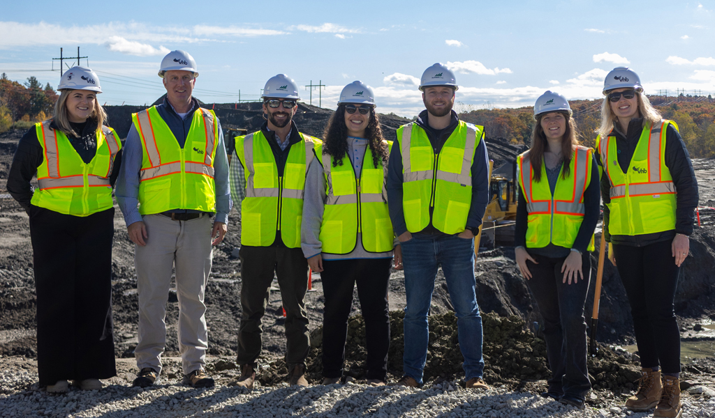 A group of people in protective gear at a groundbreaking.