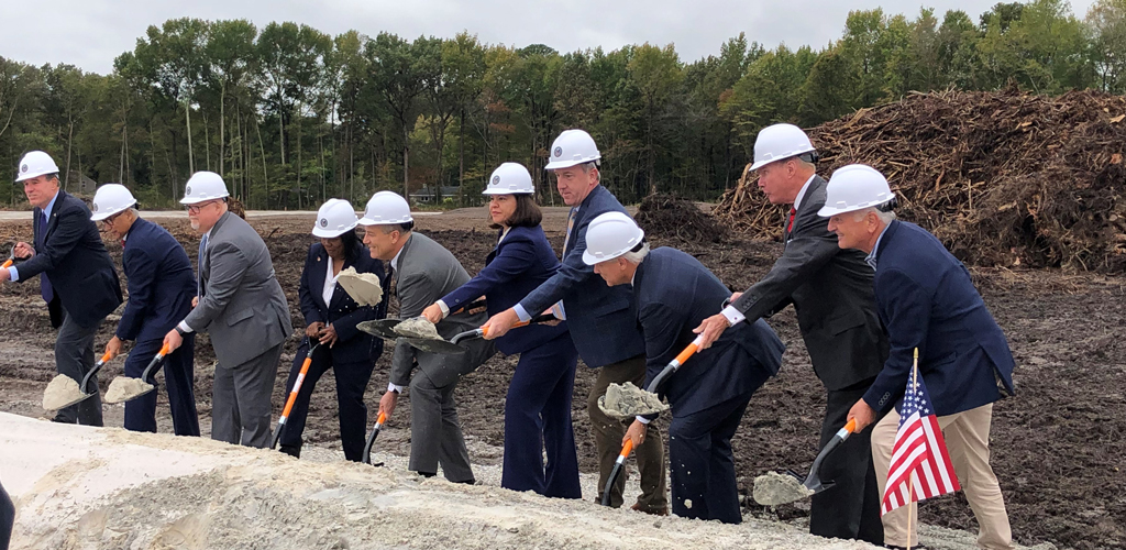 Project stakeholders hold shovels and move dirt to signify the groundbreaking of the new CBOC Hampton Roads