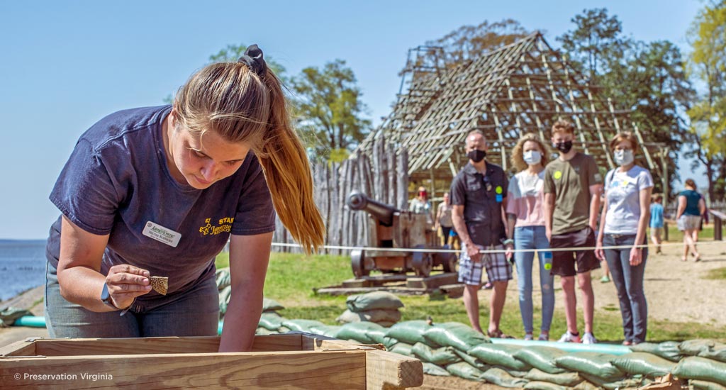 Visitors observe an archaeologist working at Historic Jamestown.