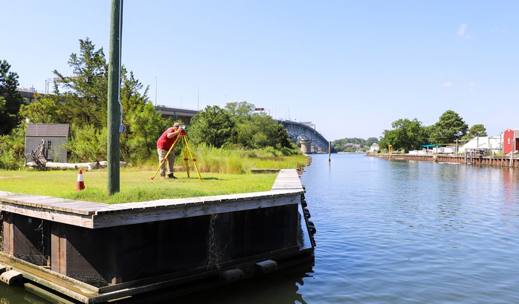 Chris Williams in action taking measurements with laser scanning technology on shore.