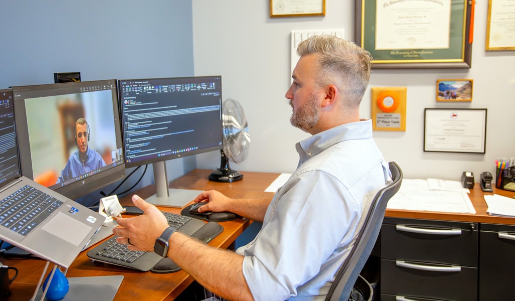 J.R. Hopson reviewing hydraulic design work on screen with a colleague at his workstation.