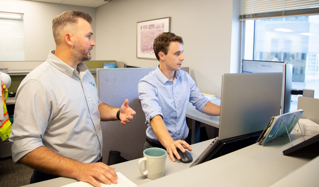 J.R. Hopson reviewing hydraulic design work on screen with a colleague at his workstation.