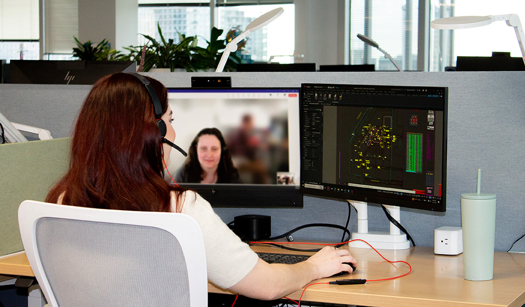 Rachel working at her desk with dual monitors showing AutoCAD designs for a healthcare facility project