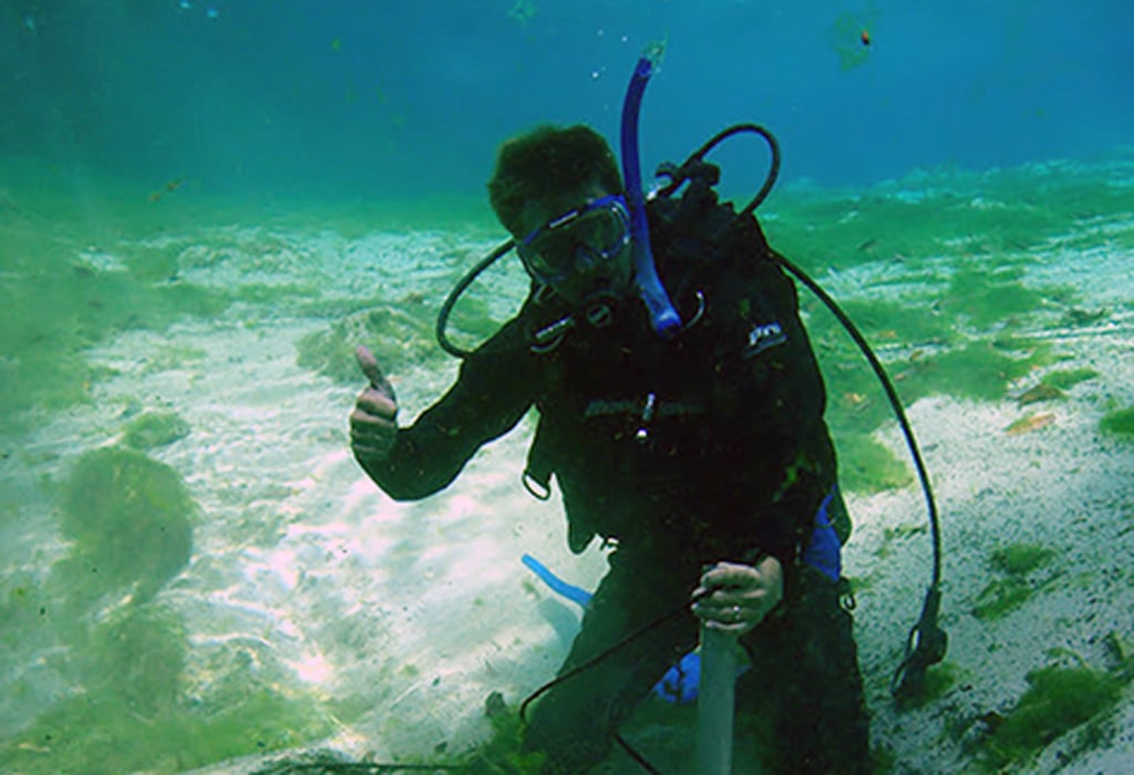 Adam Olenoski in scuba gear performing underwater work to locate 70 springs for the Kings Bay project.  
