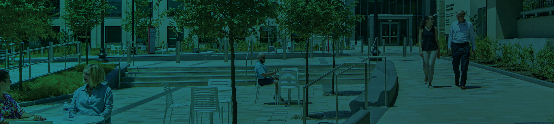 View of Children’s National Research and Innovation Center in Washington, D.C. with visitors walking on pathways and dining at outdoor tables. 