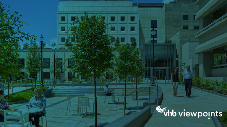 View of Children’s National Research and Innovation Center in Washington, D.C. with visitors walking on pathways and dining at outdoor tables. 