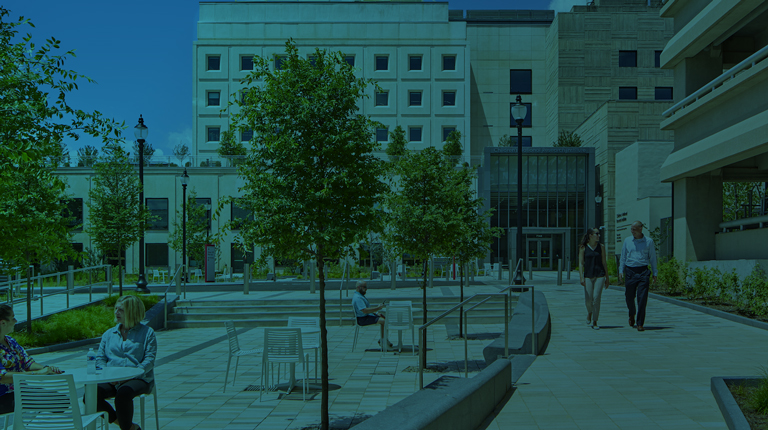 View of Children’s National Research and Innovation Center in Washington, D.C. with visitors walking on pathways and dining at outdoor tables. 