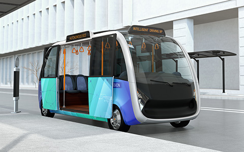 Self-driving shuttle bus waiting at bus station. The bus station equipped with solar panels for electric power.