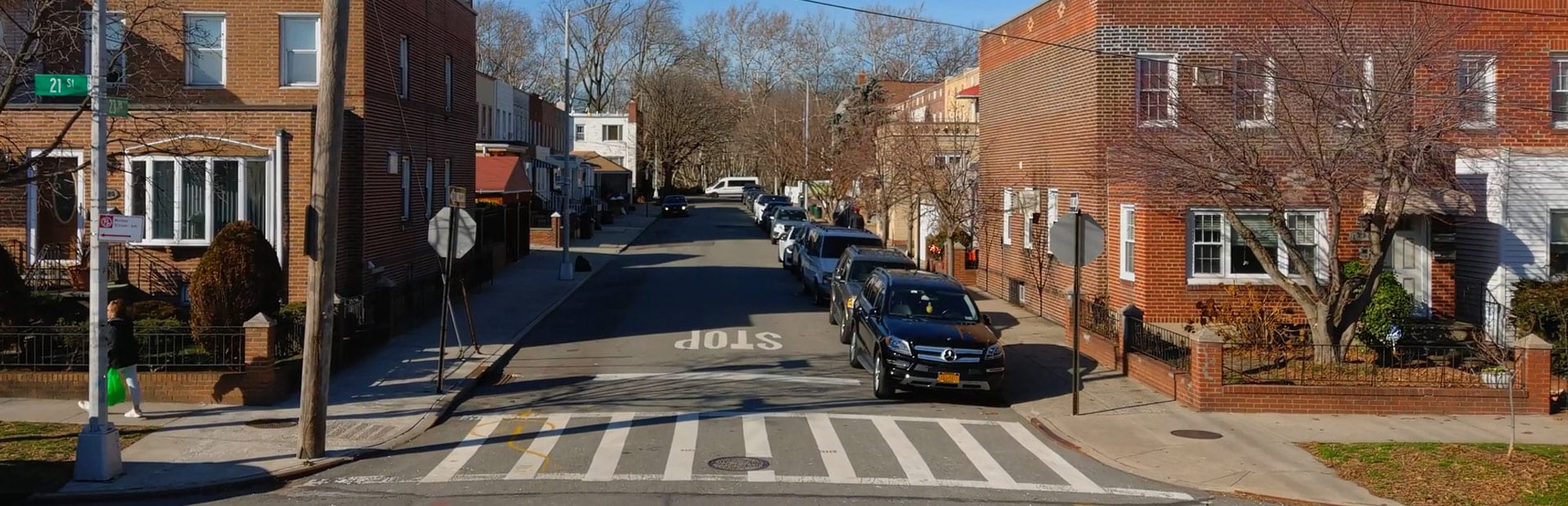A residential roadway with cars parked on the street.