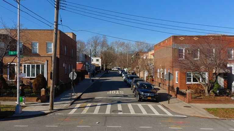 A residential roadway with cars parked on the street.