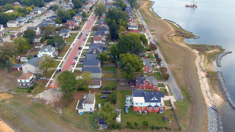 Aerial view of Ohio Creek, a residential community, with houses, trees, and roads along the waterfront.