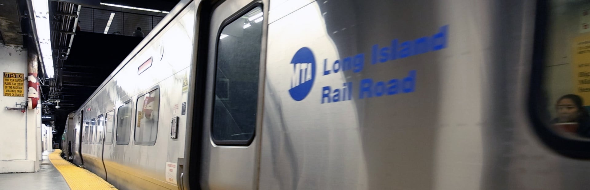 A subway train pulling into an underground station platform.