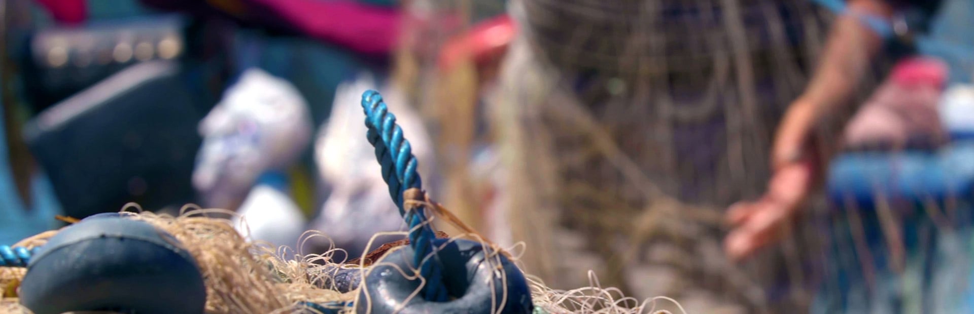 A waterman prepares fishing nets in a port.