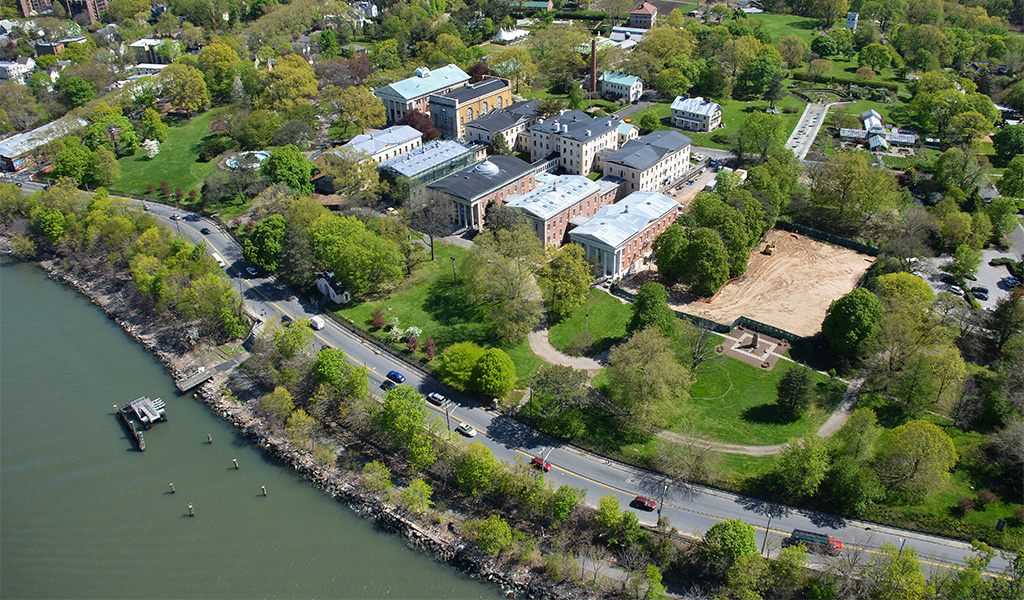 Aerial view of a town showing buildings, greenspace, roads, and water. 