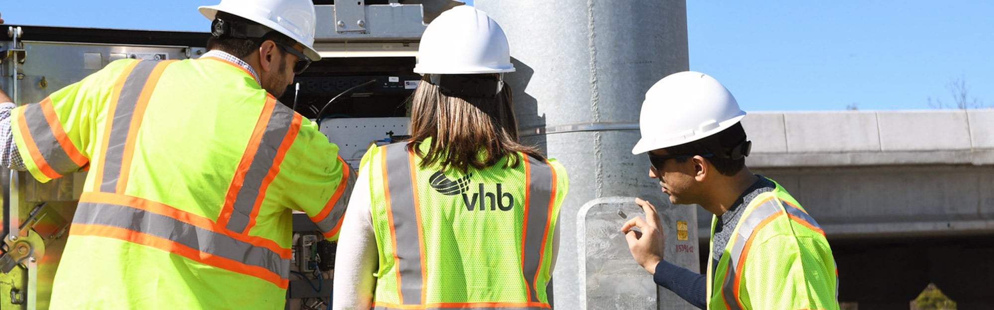 VHB team members review and test ITS equipment inside a roadside communications cabinet.