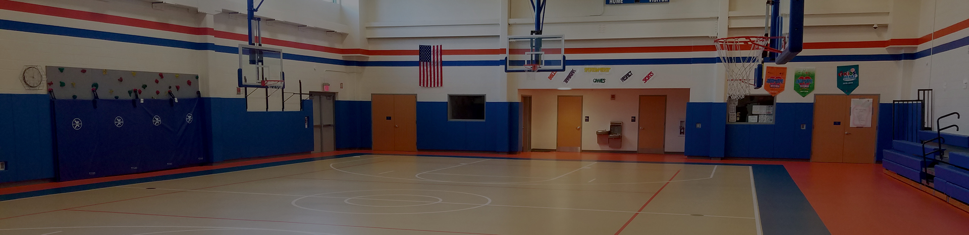 Gymnasium with multi-colored floor and blue, padded walls.