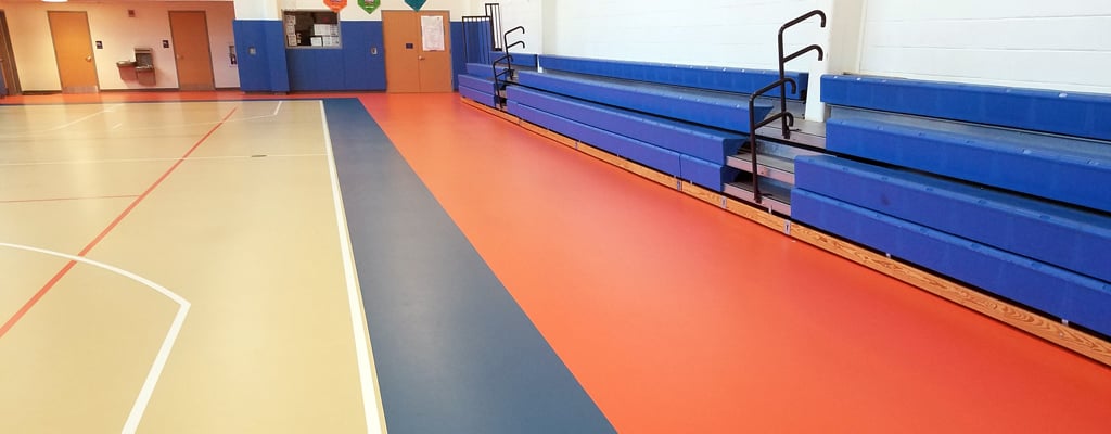 Multicolored floor that replaces mercury flooring in a gymnasium.