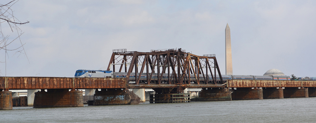 A train traveling on a bridge over water just outside of Washington, D.C.